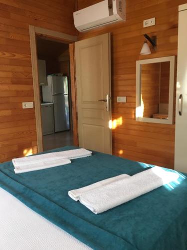 a room with a bed with two towels on it at Villa Efsane Hotel in Cıralı