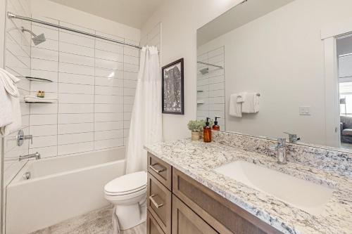Un baño con lavabo, bañera e inodoro. en Sandlewood Sanctuary, en Park City