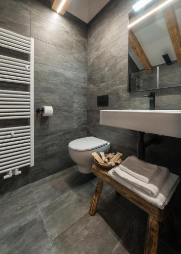 a bathroom with a white toilet and a sink at Green Hotel Genzianella in Roncone