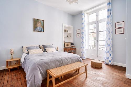une chambre blanche avec un grand lit et une fenêtre dans l'établissement Au coeur du quartier Graslin, appartement pour 3, à Nantes