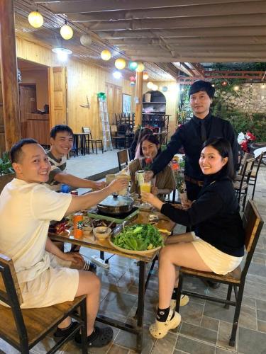 a group of people sitting at a table eating food at Meo Vac Valley in Mèo Vạc