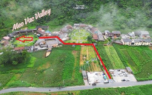 an aerial view of a large mansion with a red arrow at Meo Vac Valley in Mèo Vạc