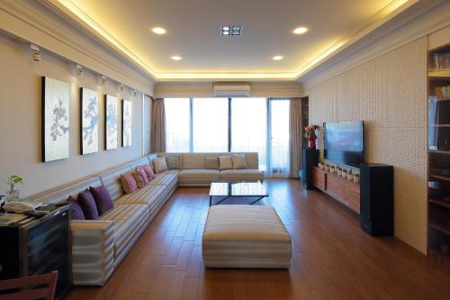 a living room with a couch and a flat screen tv at Master Homestay in Wujie