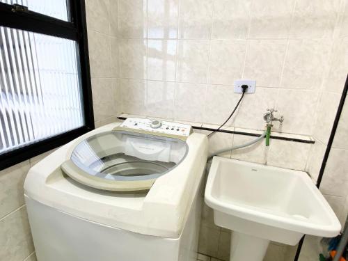 un baño con inodoro y lavabo en Edifício Saint Domingos, en Samaritá