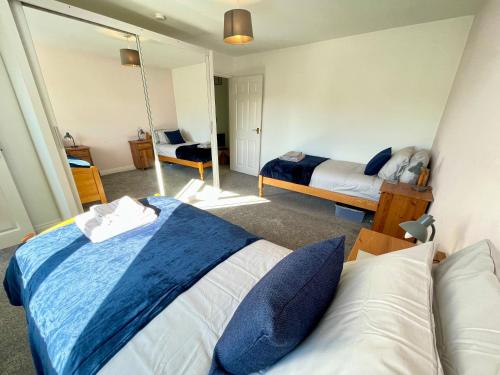 a bedroom with two beds and a mirror at Large 5 bed detached house near Stansted Airport with Parking for 2 vehicles! Stansted Stays in Stansted Mountfitchet