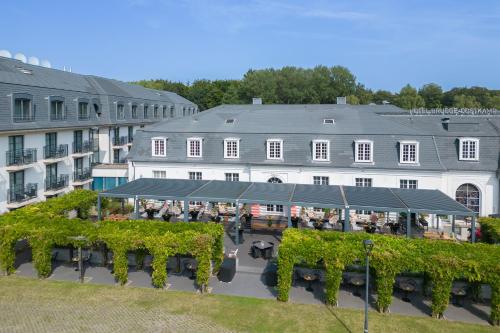 an aerial view of a hotel with a patio and a building at Van Der Valk Hotel Brugge Oostkamp in Oostkamp