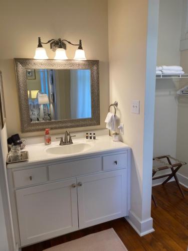 a bathroom with a white sink and a mirror at The King's Daughters B and B on the Bluff overlooking the Mighty Mississippi in Natchez