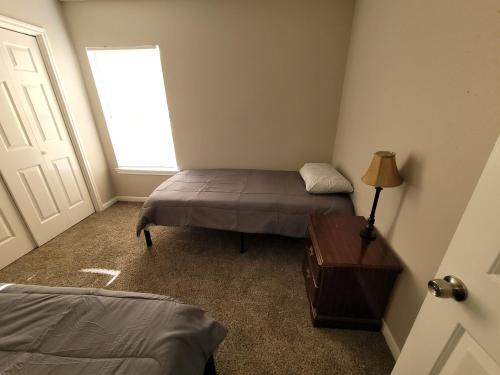 a bedroom with a bed and a lamp and a window at Fresh CrashPads 2 in Houston
