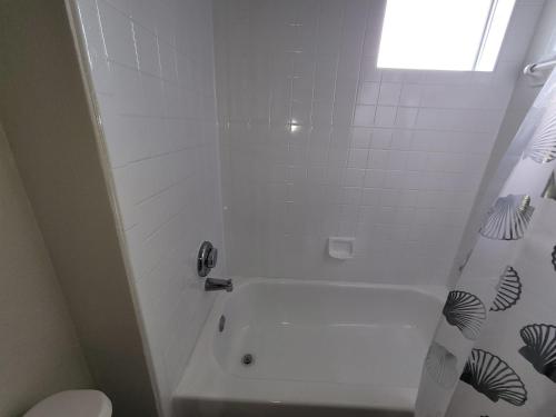 a bathroom with a white tub and a toilet at Fresh CrashPads 2 in Houston