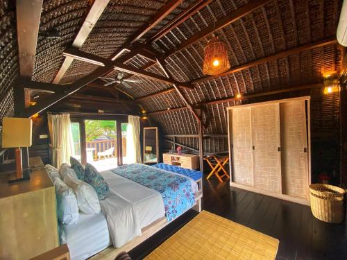 a bedroom with a bed in a room with a ceiling at Kudat Riviera Exclusive Beach Villas in Kudat