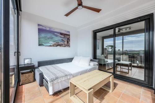 a bedroom with a bed and a couch and a table at HolaOla HighClass Townhouse in Lajares