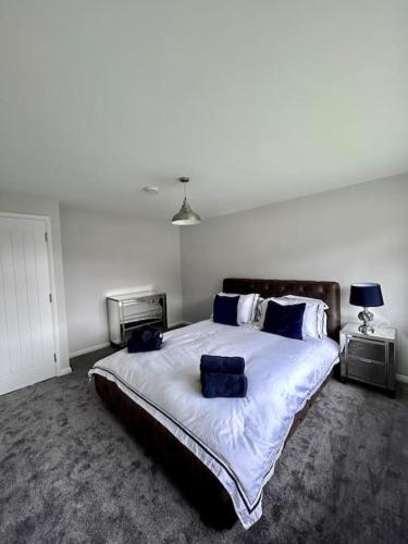 a bedroom with a large bed with blue pillows at Stunning flat in Webheath, Redditch in Redditch