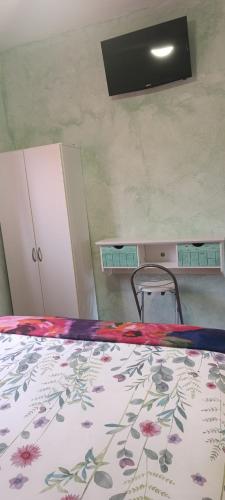 a bedroom with a bed with a floral bedspread on it at Hostal A La Sombra Del Laurel in Navarrete