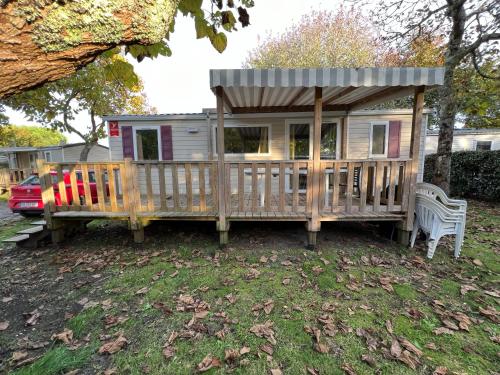 a tiny house with a porch and a bench at mobilhome 4 étoiles in Gastes