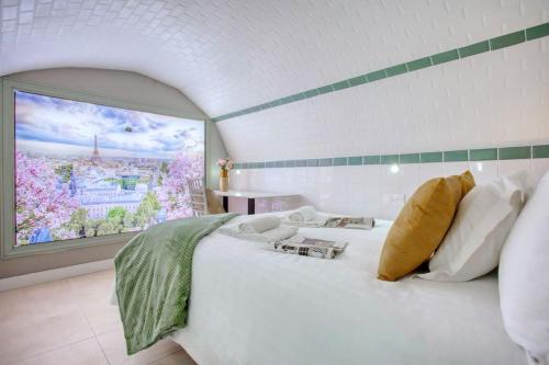 une chambre avec un grand lit blanc avec une grande fenêtre dans l'établissement Le Nid Parisien Triplex Cosy et Chaleureux, à Paris