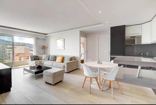 une cuisine et un salon avec un canapé et une table dans l'établissement Cannes Palm Beach - 2 chambres Vue mer, à Cannes