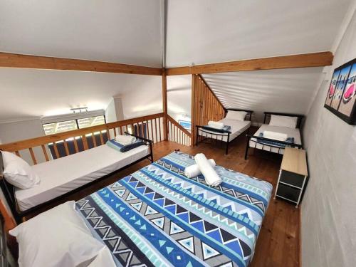a large room with two beds and a balcony at Loft Villa Pool Spa & Beach Sleeps Six! in Mandurah