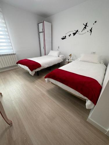 two beds in a bedroom with birds on the wall at Hostal A La Sombra Del Laurel in Navarrete