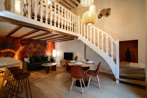 Una sala de estar con escalera y una sala de estar con mesa. en Le Savane - Grand Triplex Confort & Chaleureux, 2 Salons, en Castres