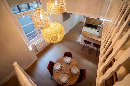 - une vue sur la salle à manger et la cuisine avec une table dans l'établissement Le Savane - Grand Triplex Climatisé, 2 Salons, à Castres