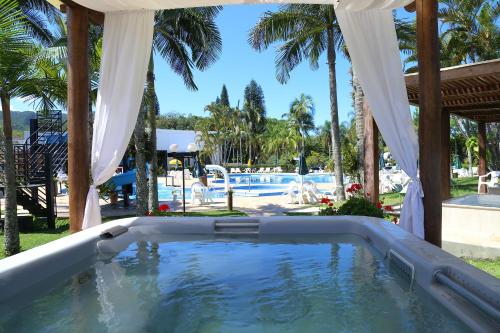 a swimming pool in a yard with palm trees at Hotel Termas Gravatal in Gravatal