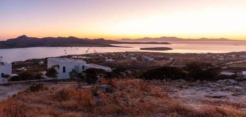 a view of a city and the ocean at sunset at Deja Blue Villa 1 in Agios Georgios