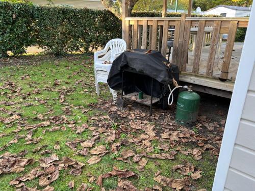 a backyard with a tent and a chair and a trash can at mobilhome 4 étoiles in Gastes