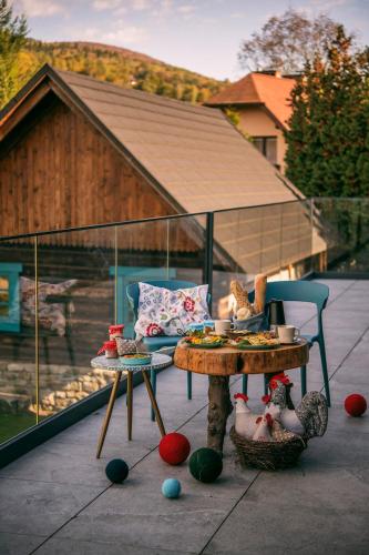 a patio with a table and chairs and a table with food on it at Kozia Chata in Brenna
