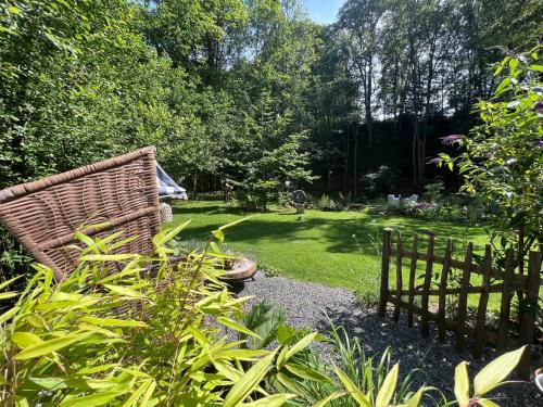a garden with a bench and a fence at Petit Château in Eupen