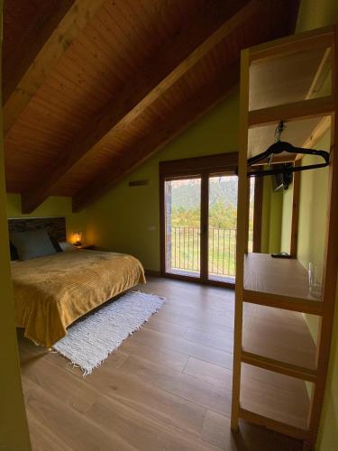 a bedroom with a bed and a large window at As Fuebas de Patricio in Vío