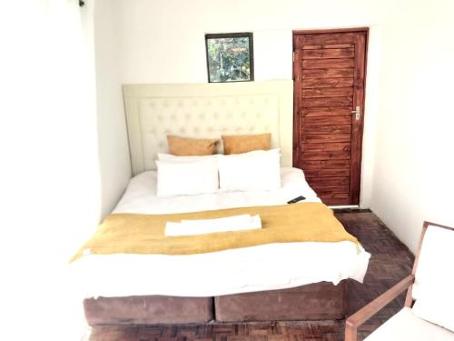 a bedroom with a large bed with white sheets at Cozy Retreat Ferndale in Johannesburg