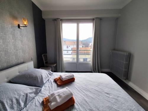 une chambre avec un lit avec deux serviettes dessus dans l'établissement Le Balcon des Pyrénées, à Lourdes
