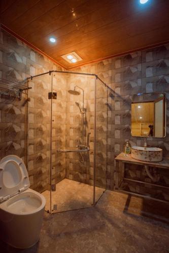 a bathroom with a shower with a toilet and a sink at Meo Vac Valley in Mèo Vạc