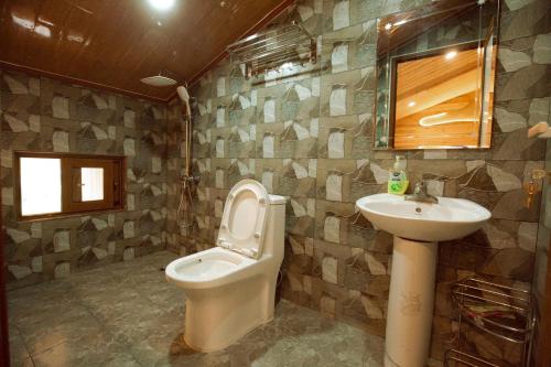 a bathroom with a toilet and a sink at Meo Vac Valley in Mèo Vạc