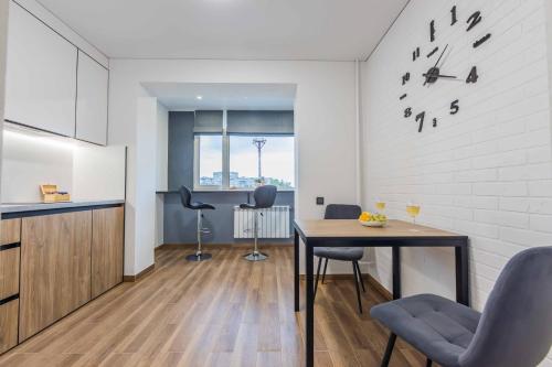 a kitchen and dining room with a table and chairs at CityApartments Kyiv Heroiv Dnipra in Kyiv