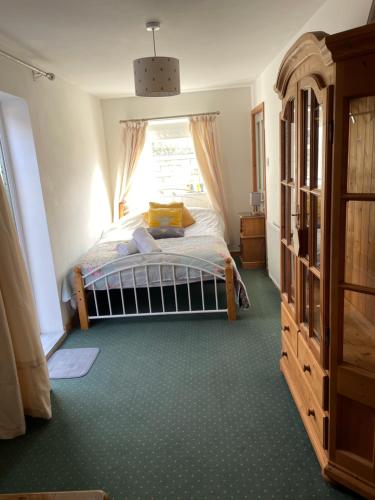 a bedroom with a bed and a window at Rose Cottage room bee happy in Newquay