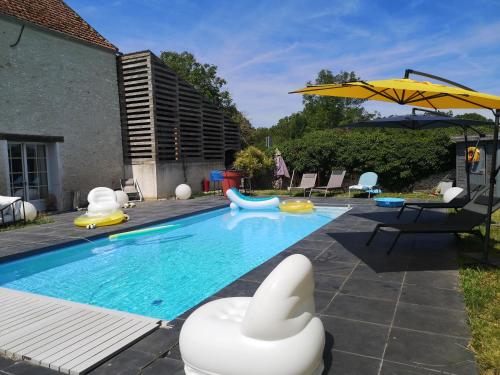 une piscine avec des chaises et un parasol dans l'établissement Le Nid - Route des impressionnistes & Giverny, à Saint-Martin-la-Garenne