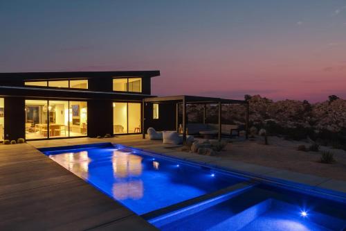 a house with a swimming pool at night at Whistling Rock By The Cohost Company in Yucca Valley Service Center Heliport