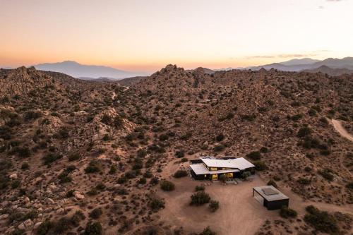 an aerial view of a house in the middle of the desert at Whistling Rock By The Cohost Company in Yucca Valley Service Center Heliport