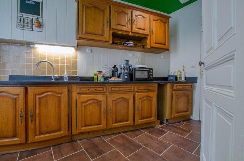 une cuisine avec des armoires en bois et un évier dans l'établissement L'annexe, à Bréviandes