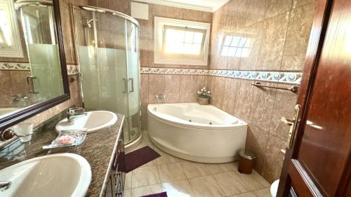 a bathroom with a tub and two sinks and a shower at Villa Lujo y Relax in Adeje by Deihu Experiences in Adeje