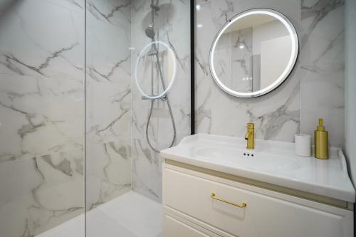 une salle de bain blanche avec un lavabo et un miroir dans l'établissement Le Baroque - Grand T2 Calme, Lit Queen Size, à Castres