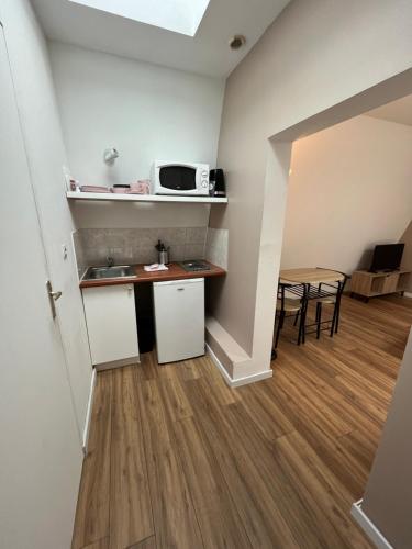 Il comprend une petite cuisine et une salle à manger avec une table. dans l'établissement Créma, Studio proche centre ville, à Caen