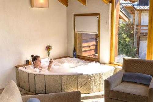 a woman in a bath tub in a living room at Galileo Boutique Hotel in San Carlos de Bariloche