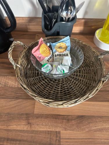 a basket filled with snacks on a table at Drum Manor Apartment Hillsborough BT26 6PU in Hillsborough