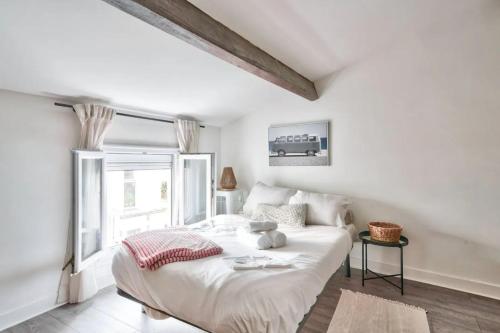 un lit blanc dans une chambre avec une fenêtre dans l'établissement GuestReady - Bright Stay in the Heart of Paris, à Paris