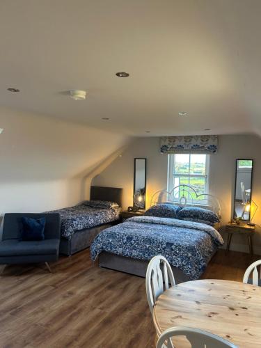 a bedroom with three beds and a table and a couch at Drum Manor Apartment Hillsborough BT26 6PU in Hillsborough