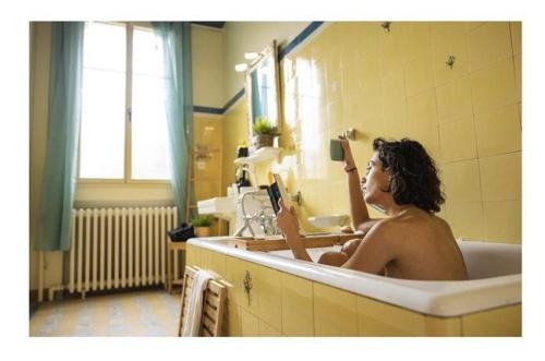 un homme assis dans une baignoire prenant un selfie dans l'établissement L'instant champenois & son annexe, à Bréviandes