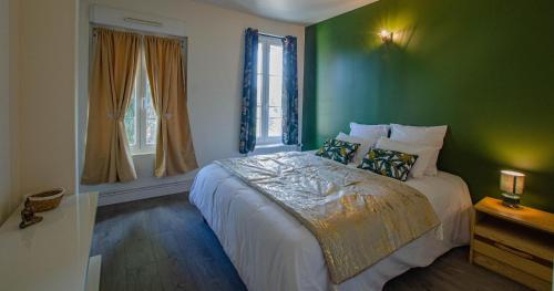 - une chambre dotée d'un lit avec un mur vert dans l'établissement L'instant champenois & son annexe, à Bréviandes