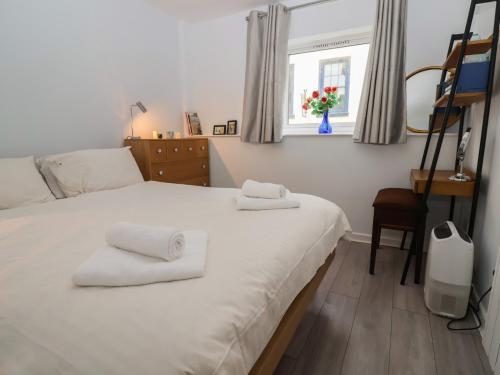 Un dormitorio con una cama con toallas. en 10 Bay View Court, en Lyme Regis
